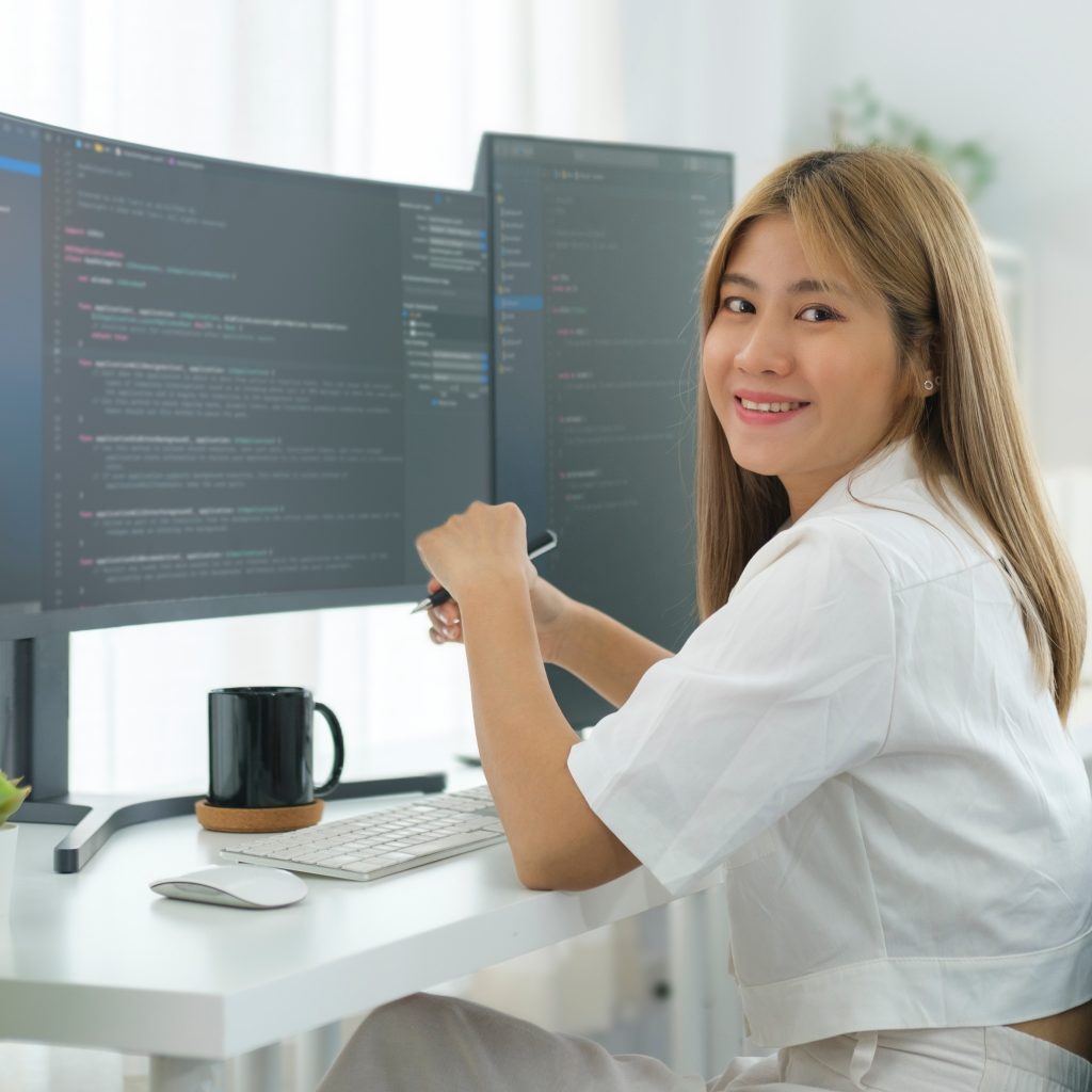 Skilled young female coder in casual clothes working with program